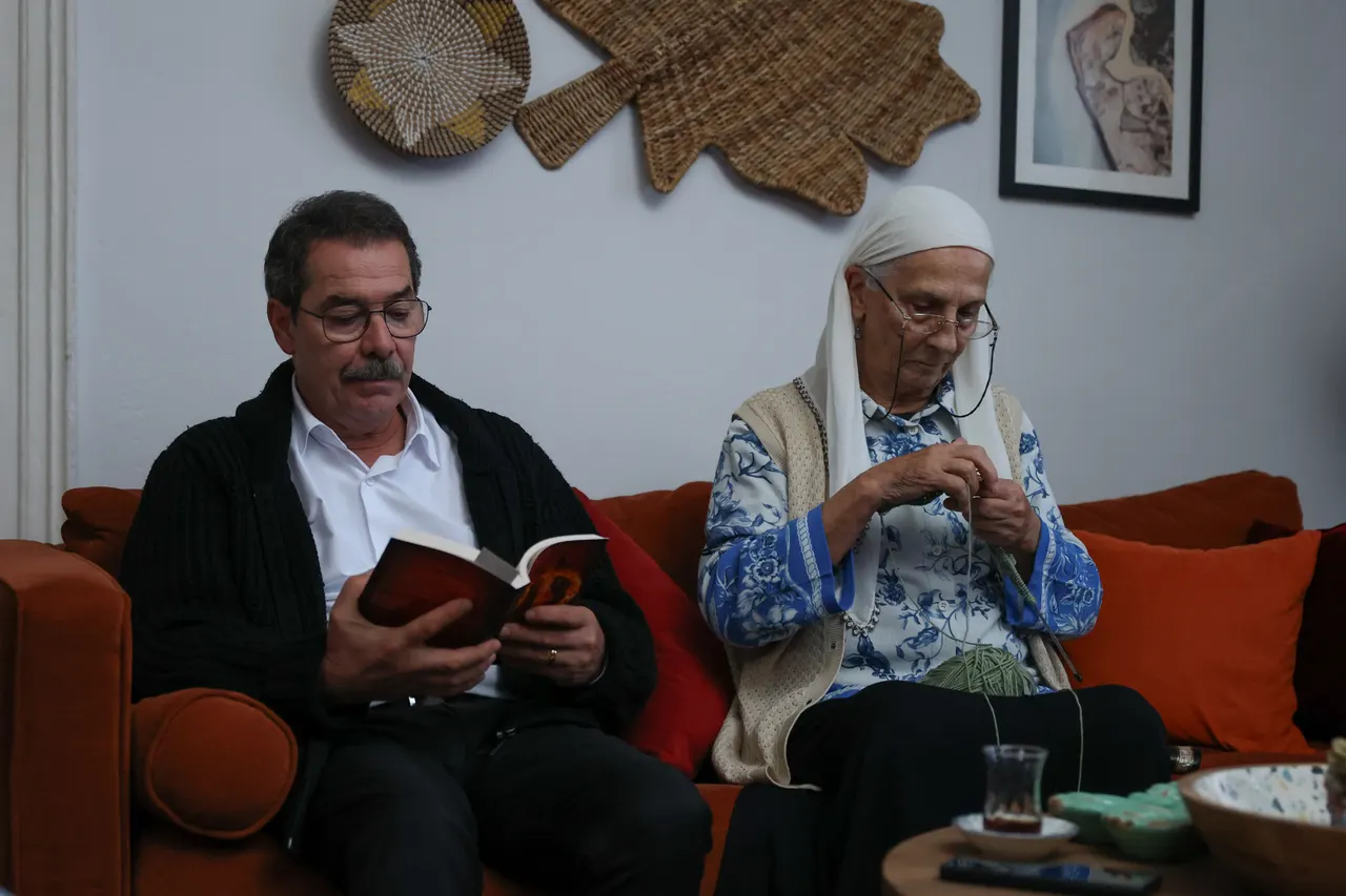 İki yaşlı erkek ellerinde kitaplarla kanepede oturuyor.