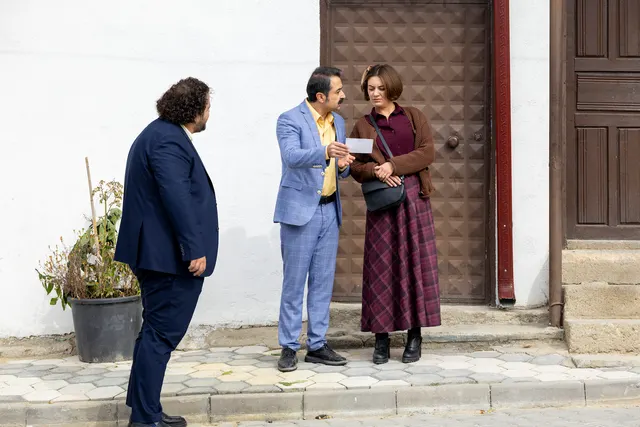 Gönül Dağı dizisinden bir sahnede bina girişinde buluşan iki erkek ve bir kadın birlikte görülüyor.