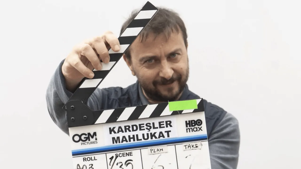Ali Atay sette Kardeşler Mahlukat klaketini tutuyor.