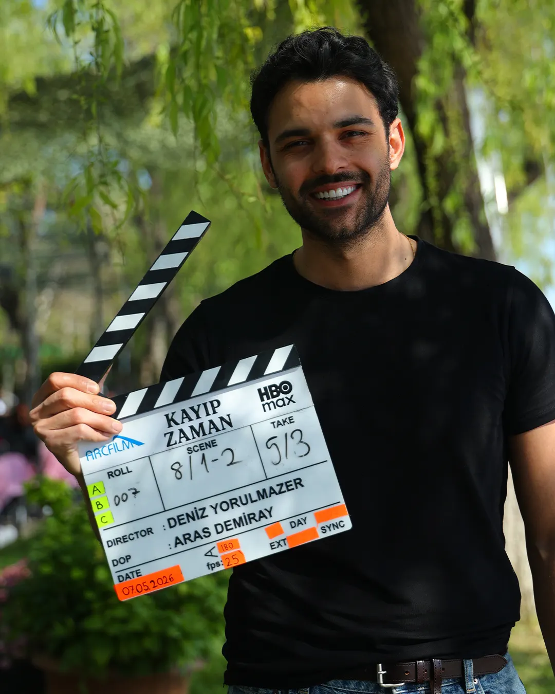 Berk Bakioğlu açık hava çekiminde dizinin klaketini tutuyor.