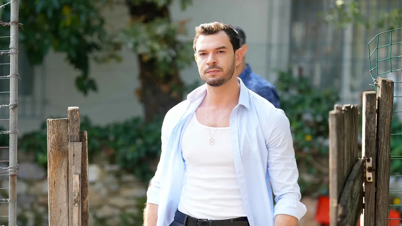 Beyaz gömlekli bir erkek bahçe kapısında duruyor.